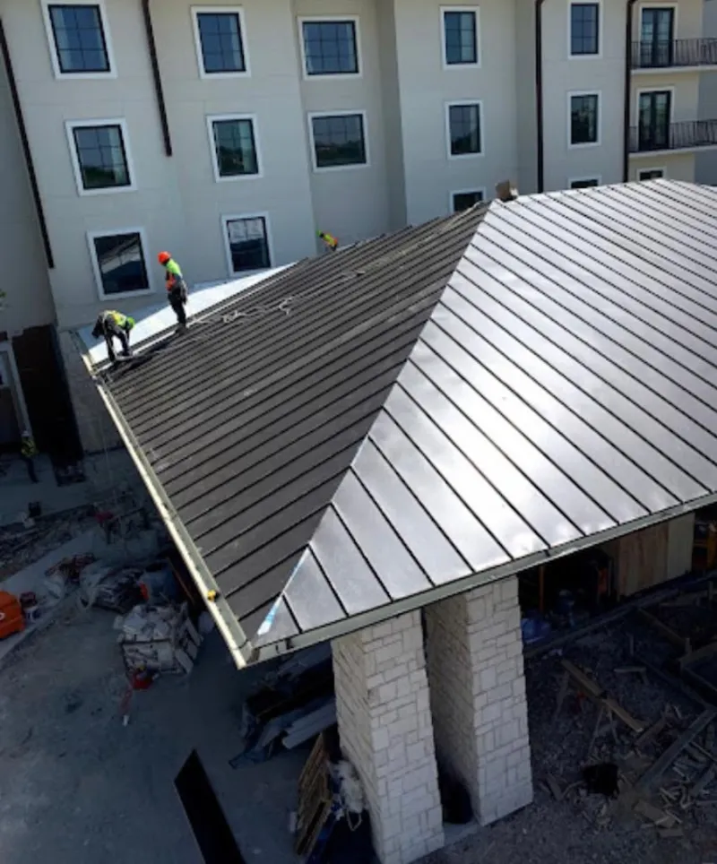 Crew installing standing seam metal roof panels on a commercial project in West Hollywood